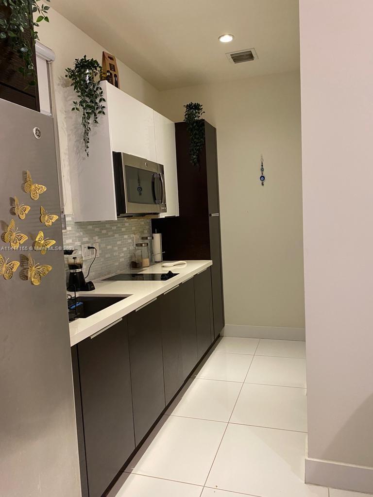 Doral Doral, FL 33178 - Photo 11 of 16 a kitchen with a sink and a microwave