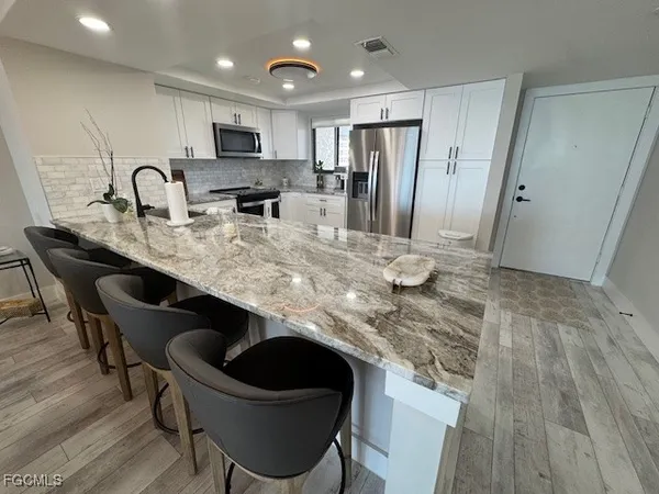 a kitchen with kitchen island a sink stove and refrigerator
