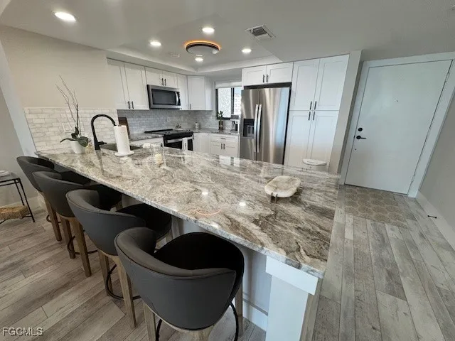 a kitchen with kitchen island a sink stove and refrigerator