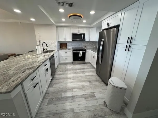 a large kitchen with a sink a toilet and a refrigerator