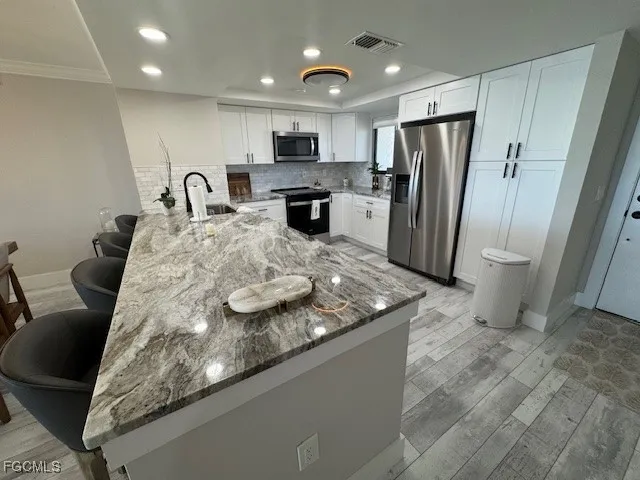 a kitchen with stainless steel appliances granite countertop a sink refrigerator and cabinets