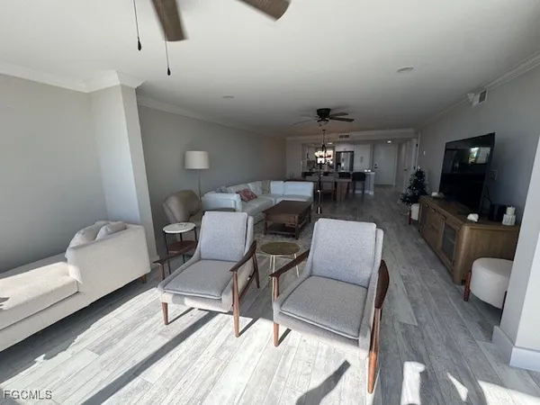 a living room with furniture a flat screen tv and a rug