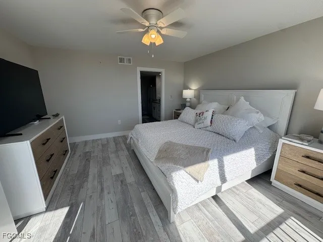 a bedroom with a bed and a flat tv screen on dresser