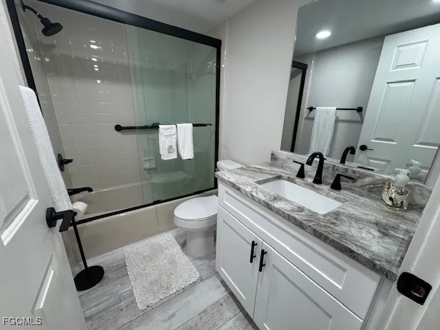 a bathroom with a granite countertop sink a toilet and a mirror
