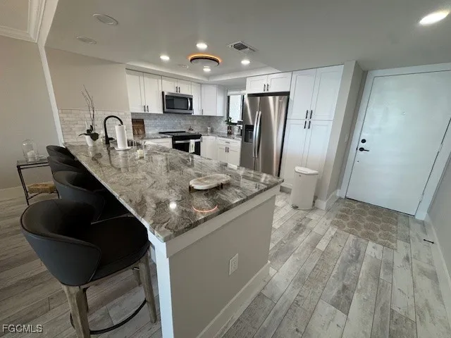 a kitchen with stainless steel appliances granite countertop a sink refrigerator and cabinets