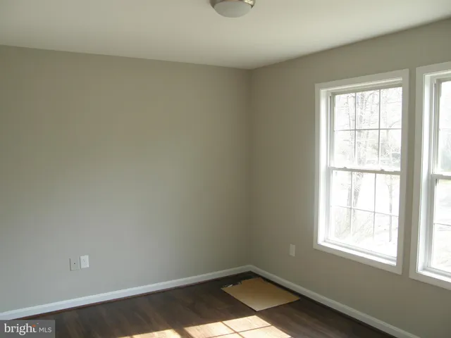a view of a small space with wooden floor and a window