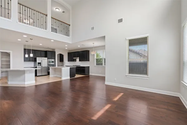 a view of a livingroom with wooden floor and a kitchen
