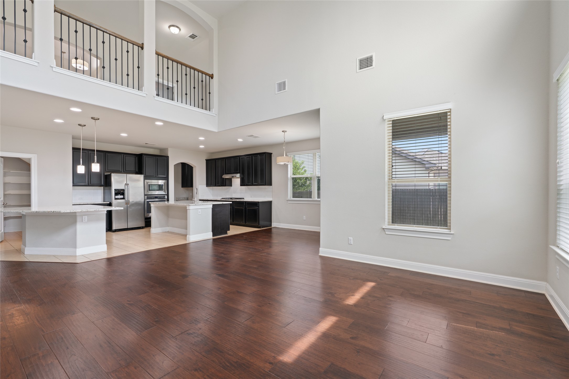 15601 Cabrillo Way Austin, TX 78738 - Photo 19 of 32 Open-concept living space with high ceilings and rich wood-finish flooring