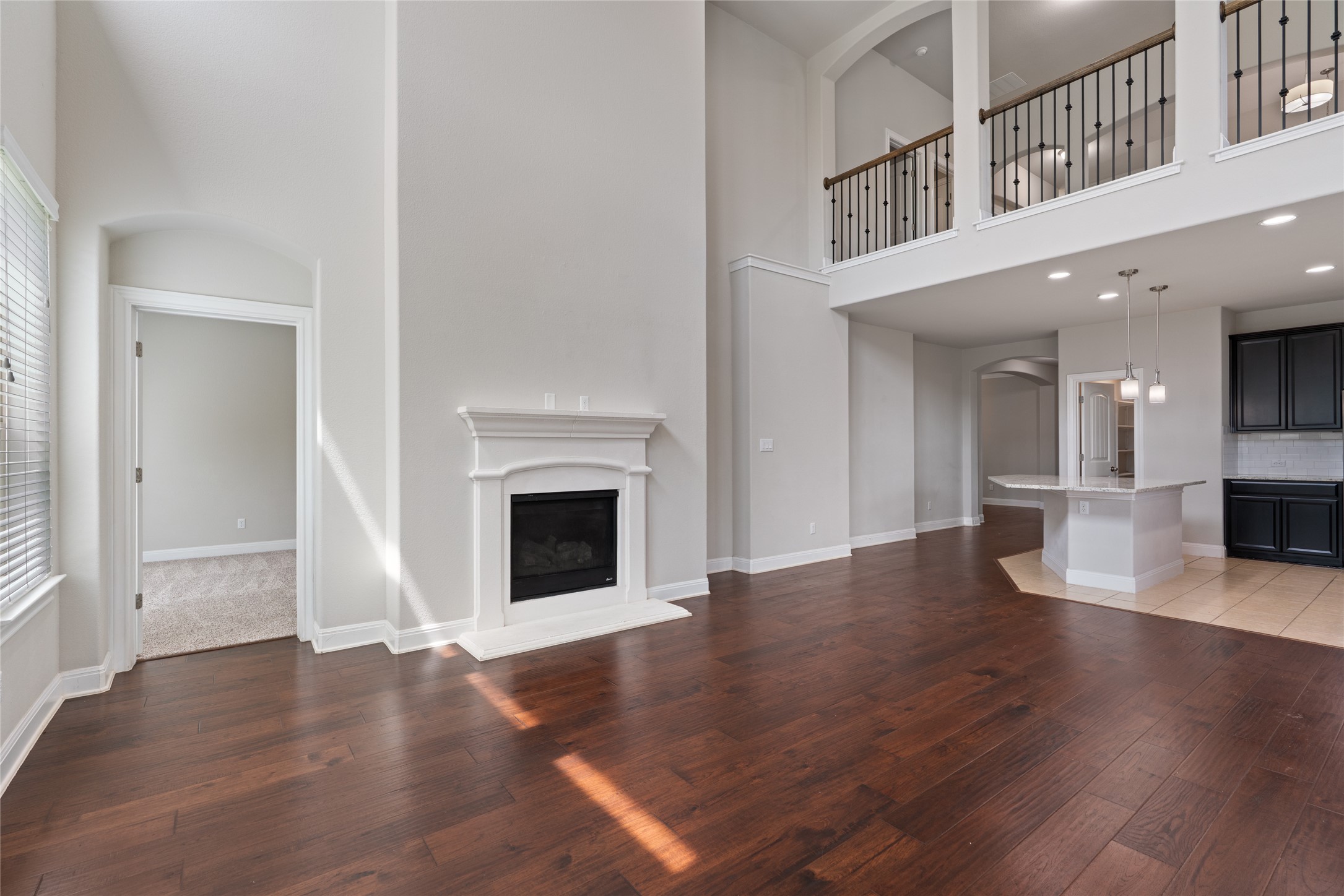15601 Cabrillo Way Austin, TX 78738 - Photo 20 of 32 Spacious living area featuring high ceilings, wood-finish flooring, and a white fireplace with a mantel