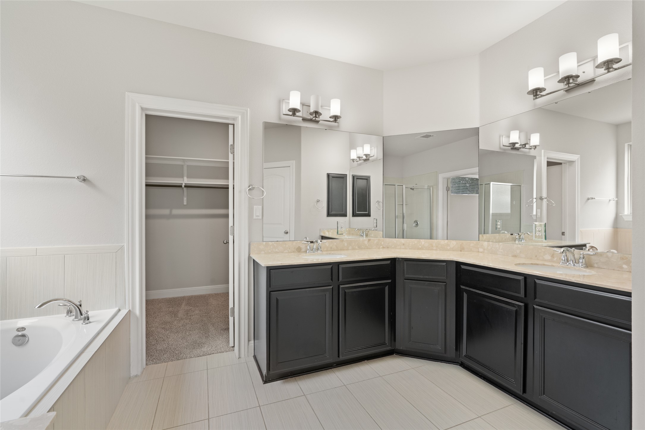 15601 Cabrillo Way Austin, TX 78738 - Photo 24 of 32 Bathroom featuring a corner vanity with dual sinks, light-toned countertops, and dark cabinetry