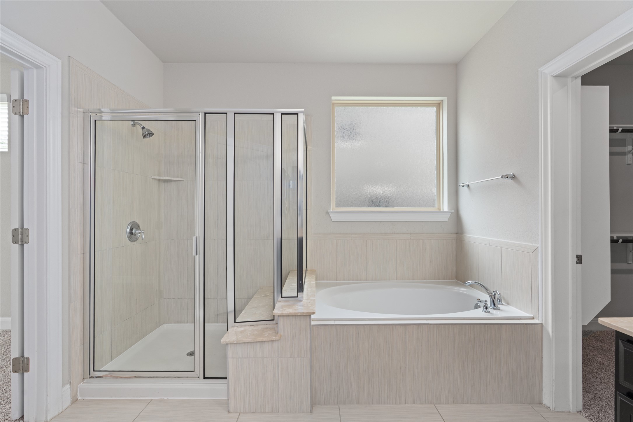 15601 Cabrillo Way Austin, TX 78738 - Photo 25 of 32 Bathroom featuring a tiled soaking tub and a separate glass-enclosed shower with tile surround