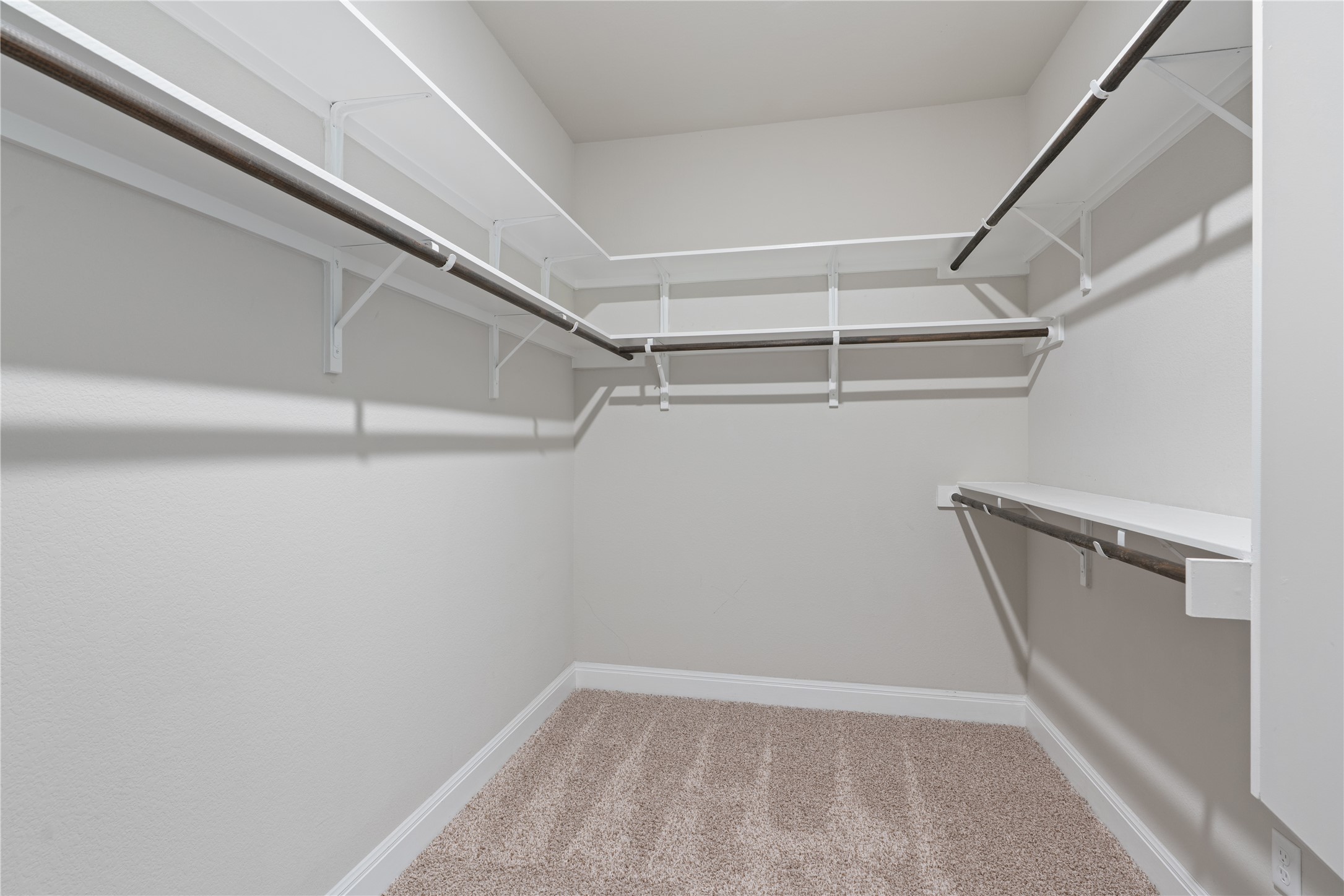 15601 Cabrillo Way Austin, TX 78738 - Photo 26 of 32 Spacious walk-in closet featuring white wire shelving, multiple hanging rods, and light-toned carpeting