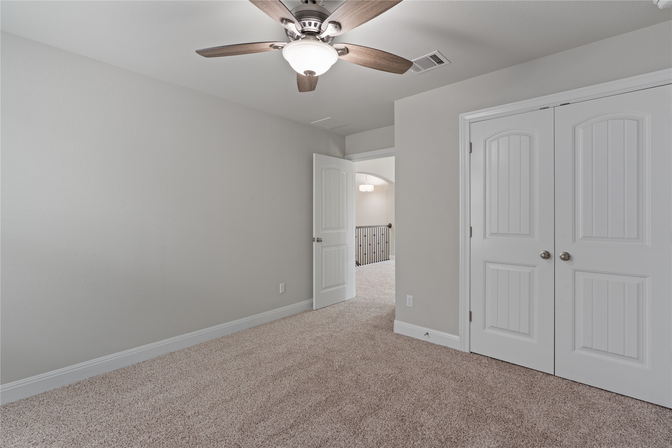 15601 Cabrillo Way Austin, TX 78738 - Photo 28 of 32 Carpeted room featuring light gray walls, a ceiling fan with light fixture, and white bi-fold closet doors
