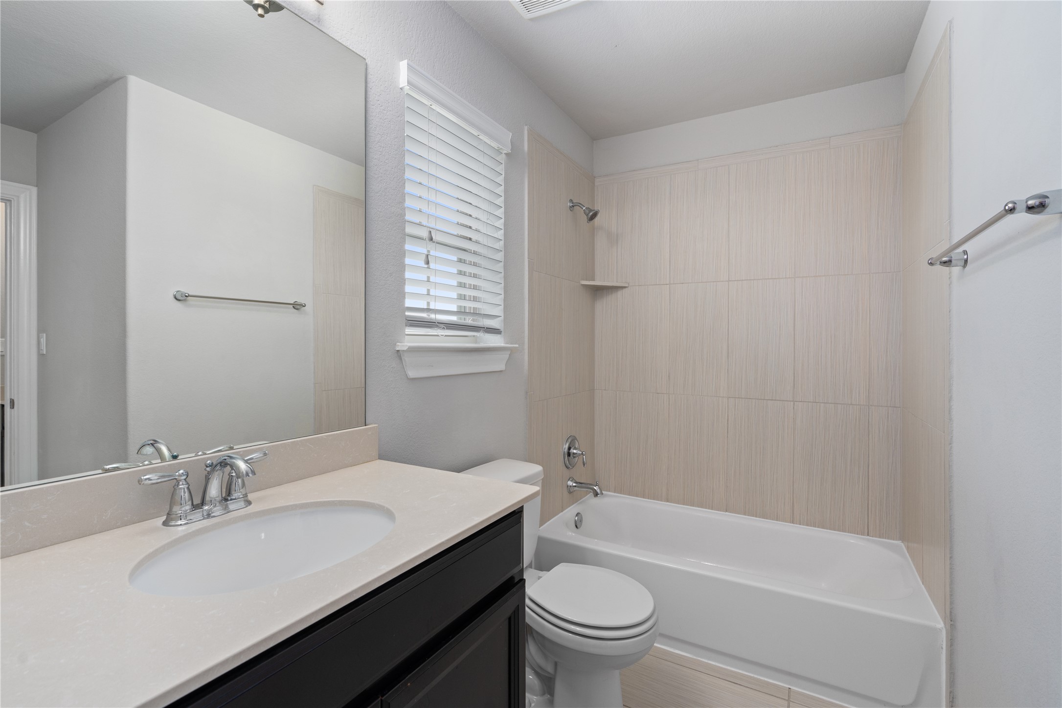 15601 Cabrillo Way Austin, TX 78738 - Photo 30 of 32 Bathroom featuring a dark wood-finish vanity with an undermount sink, a light-toned countertop, and a large mirror