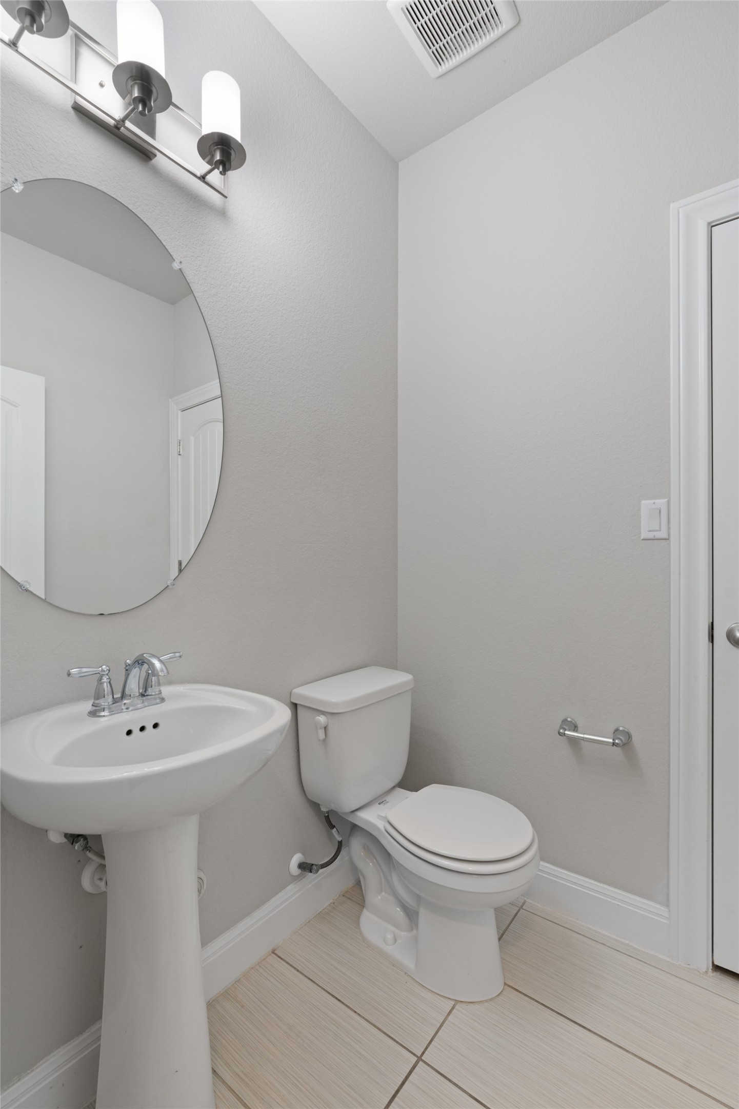 15601 Cabrillo Way Austin, TX 78738 - Photo 6 of 32 Pedestal sink with chrome faucet, circular wall-mounted mirror, and a contemporary vanity light fixture