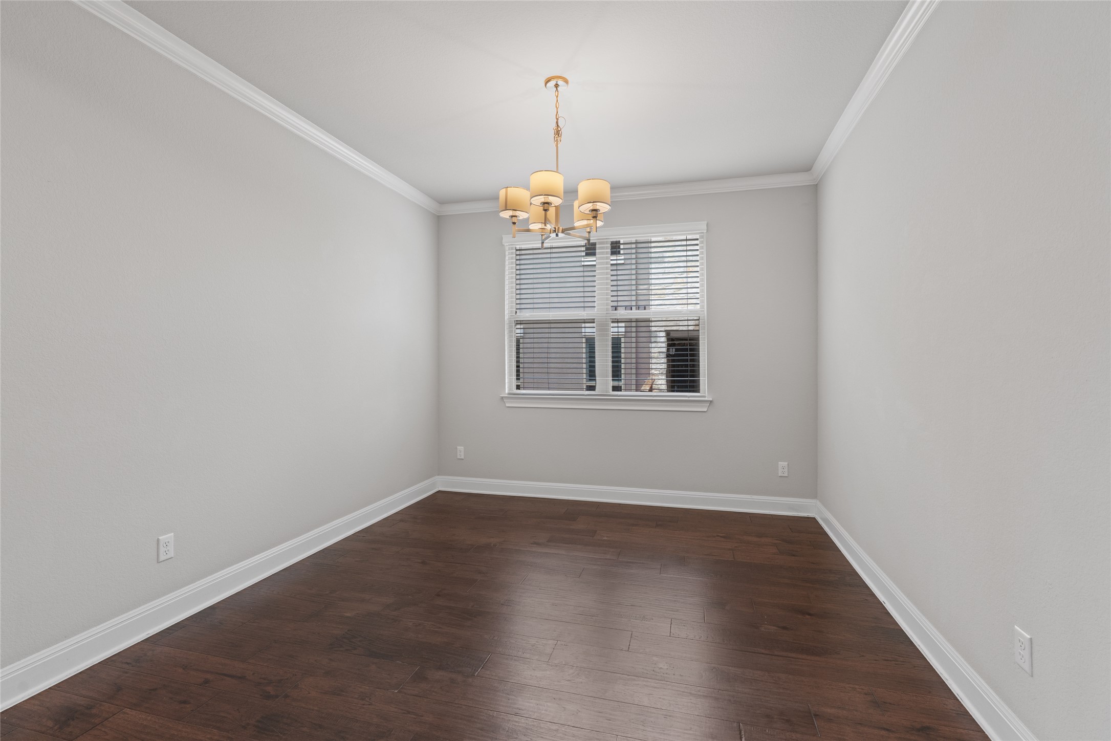 15601 Cabrillo Way Austin, TX 78738 - Photo 7 of 32 Room featuring wood-finish flooring, white baseboards, crown molding, and a central chandelier
