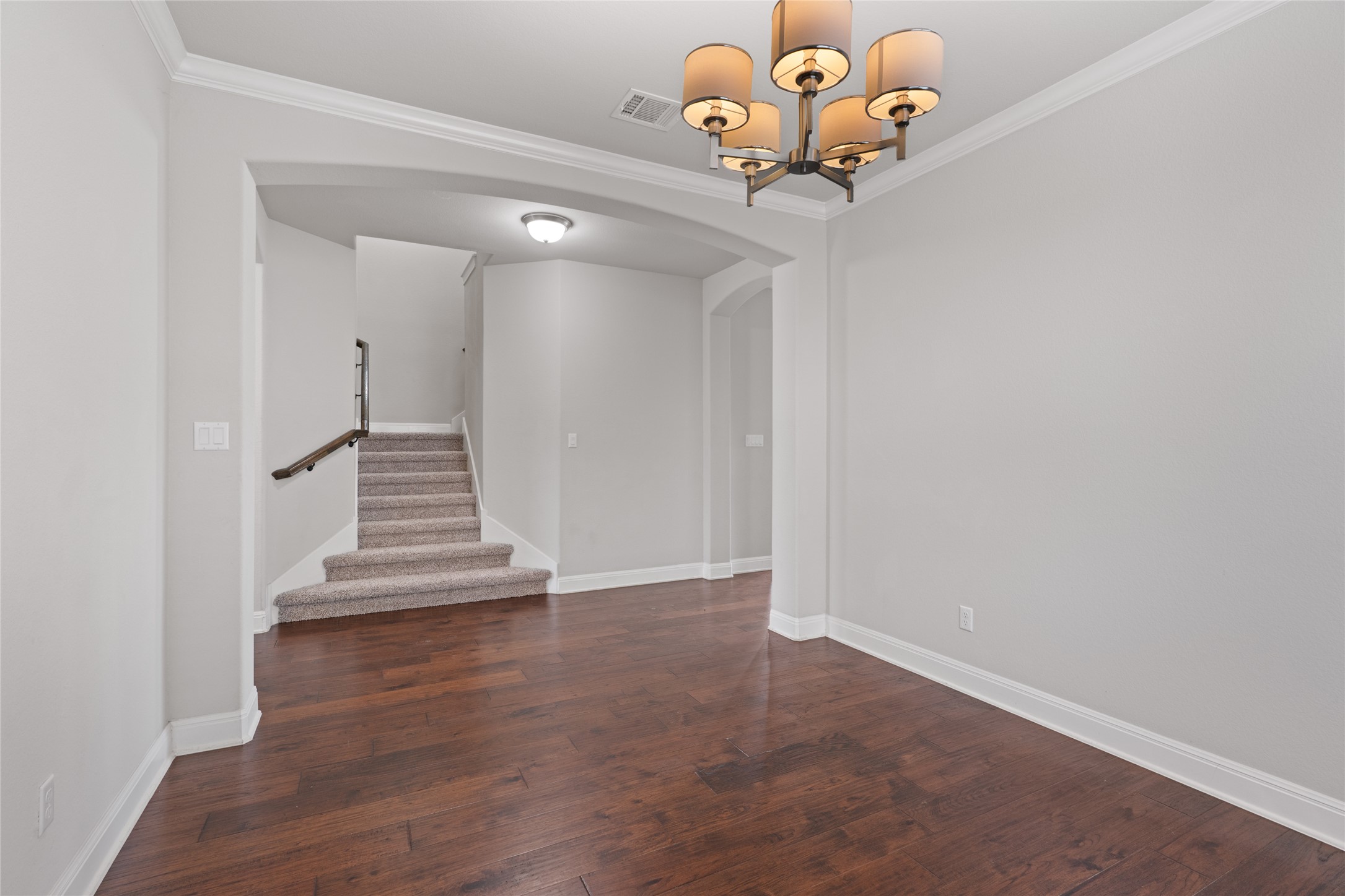 15601 Cabrillo Way Austin, TX 78738 - Photo 8 of 32 Hardwood flooring, painted light gray walls, white baseboards, crown molding, and a bronze chandelier with drum shades