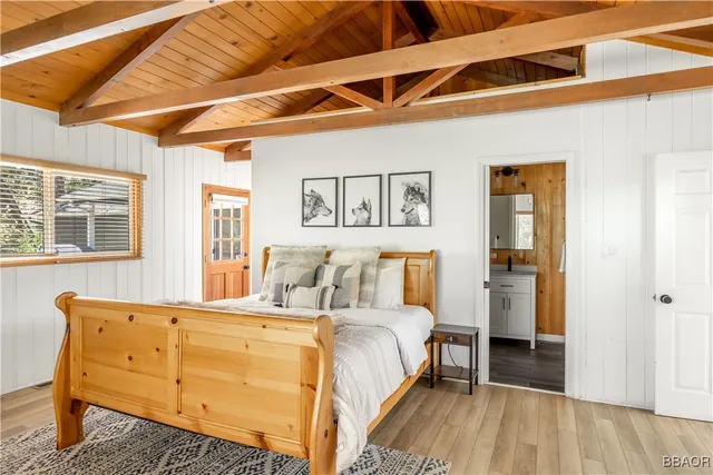 a view of a bedroom with wooden floor and windows