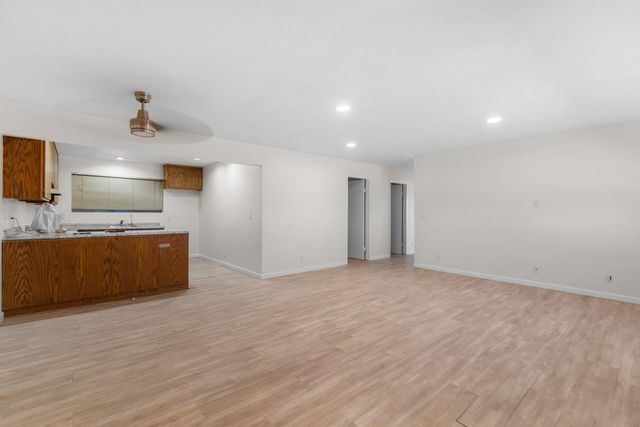 a kitchen with stainless steel appliances granite countertop wooden cabinets a stove a sink and a refrigerator