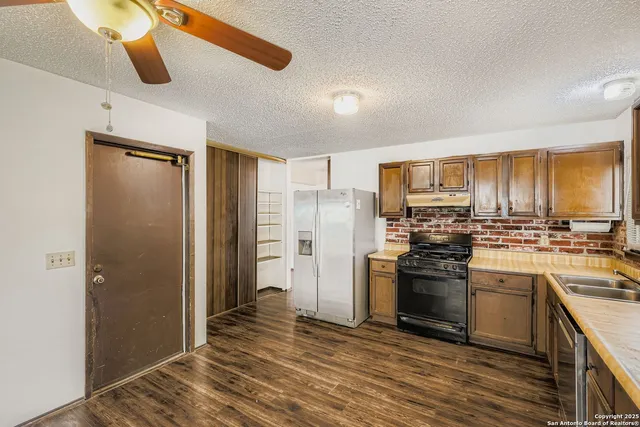 a kitchen with stainless steel appliances granite countertop a stove and cabinets with wooden floor