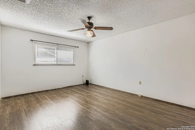 a view of an empty room with wooden floor