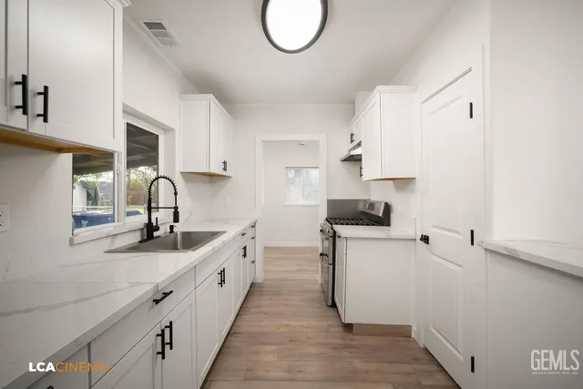 a kitchen with granite countertop a sink and a stove top oven