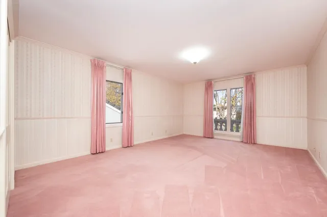 an empty room with windows and closet