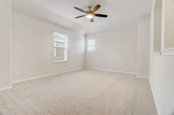 an empty room with a window and a fan