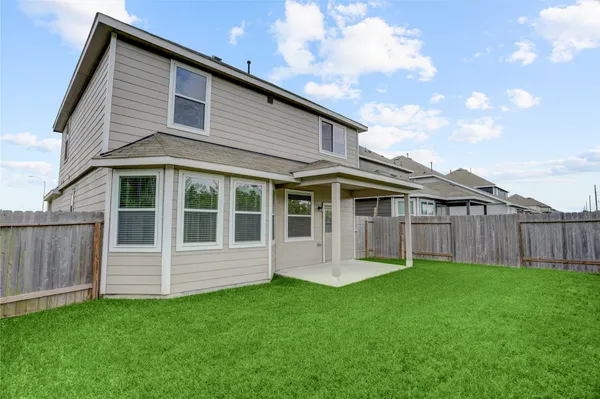 a view of a house with a yard and wooden fence