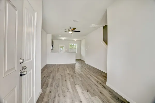 a view of a hallway with wooden floor and a window