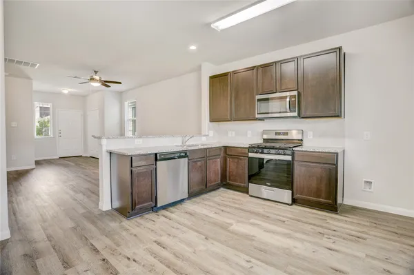 a kitchen with stainless steel appliances granite countertop a stove a sink and a refrigerator
