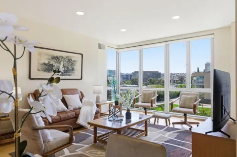 a living room with furniture large windows and a flat screen tv
