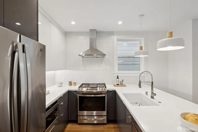 a kitchen with stainless steel appliances a sink stove and refrigerator