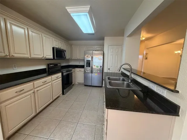 a kitchen with a sink a stove top oven and cabinetry