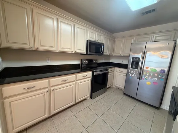 a kitchen with white cabinets stainless steel appliances and sink