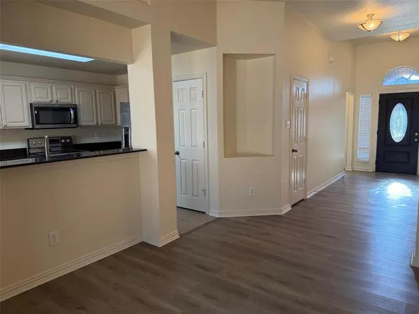 a view of a kitchen with wooden floor and a sink