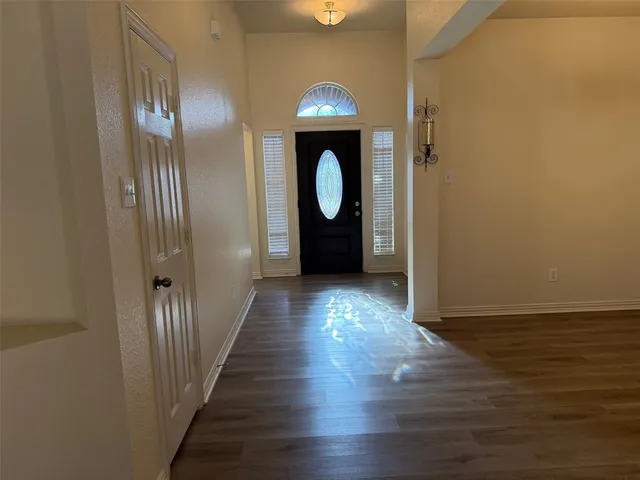 a view of a livingroom with wooden floor and entrance