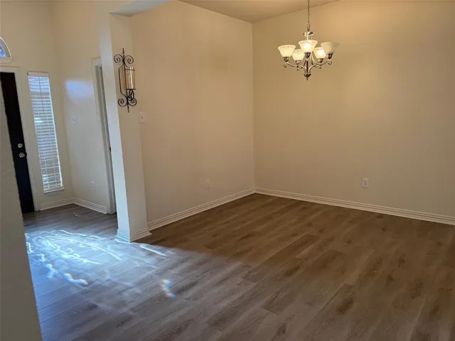an empty room with wooden floor and entrance