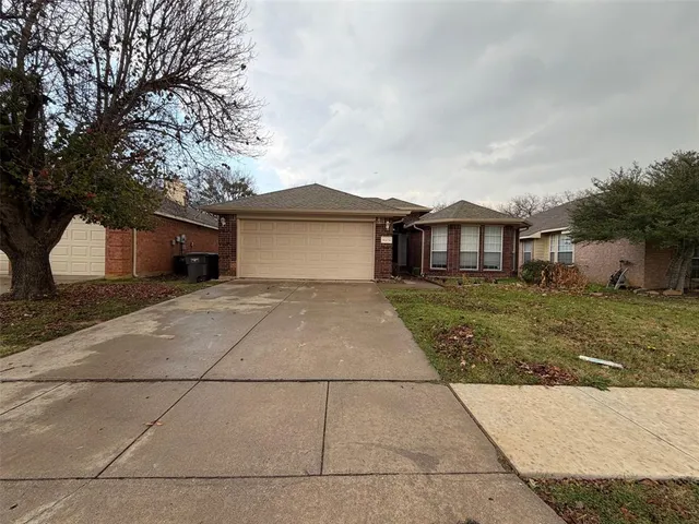 a front view of a house with a garden and trees