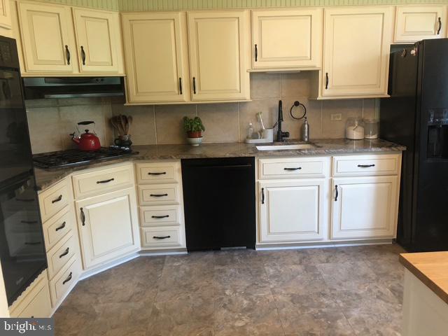 12 Windsor Circle Springfield, PA 19064 - Photo 13 of 28 a kitchen with granite countertop white cabinets and stainless steel appliances
