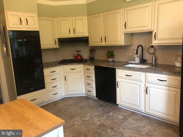 12 Windsor Circle Springfield, PA 19064 - Photo 14 of 28 a kitchen with stainless steel appliances granite countertop a sink stove and refrigerator