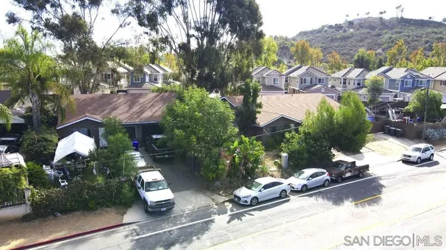 an aerial view of a house with a garden and mountain view in back
