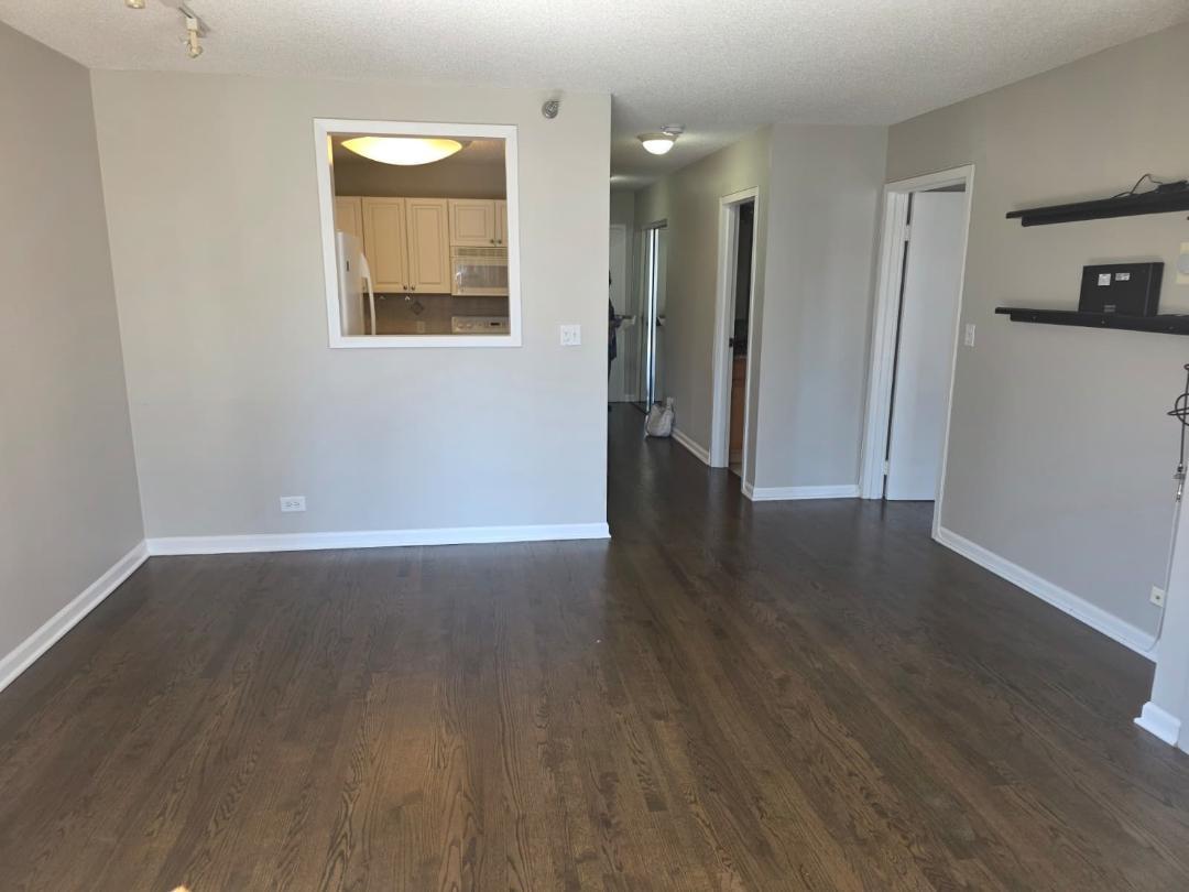 33 West Delaware Place, Unit 10G Chicago, IL 60610 - Photo 7 of 11 an empty room with wooden floor and a window