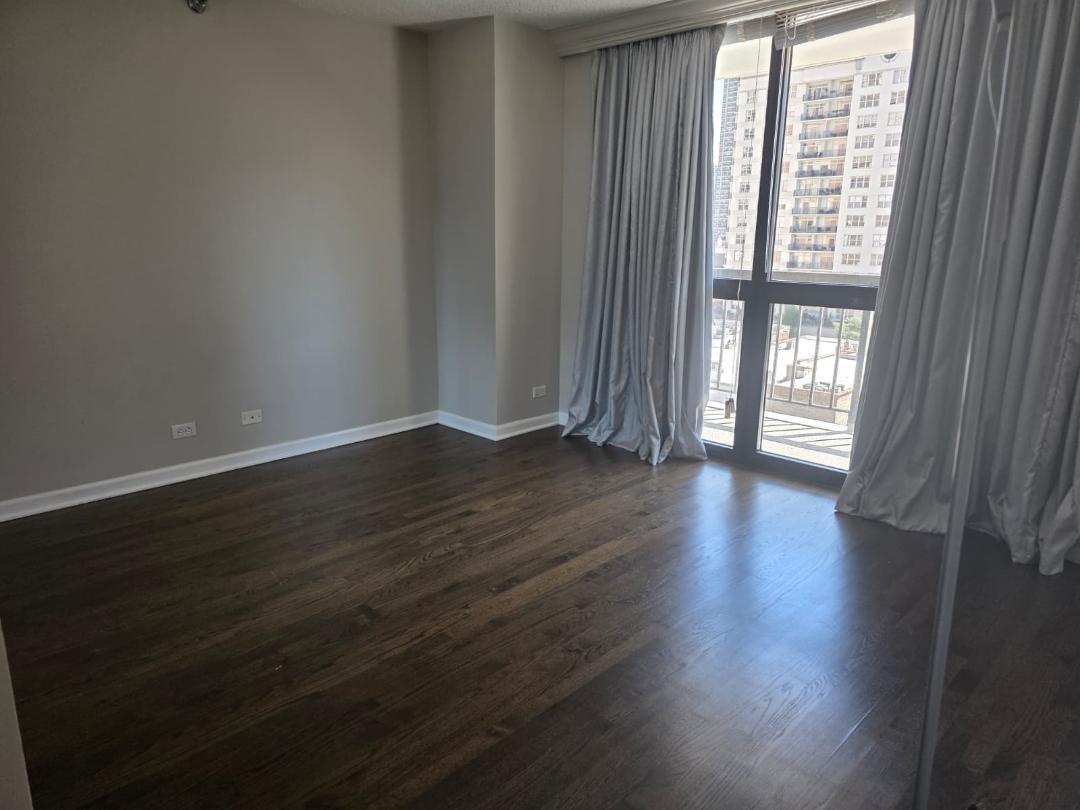 33 West Delaware Place, Unit 10G Chicago, IL 60610 - Photo 10 of 11 a view of an empty room with wooden floor and a window