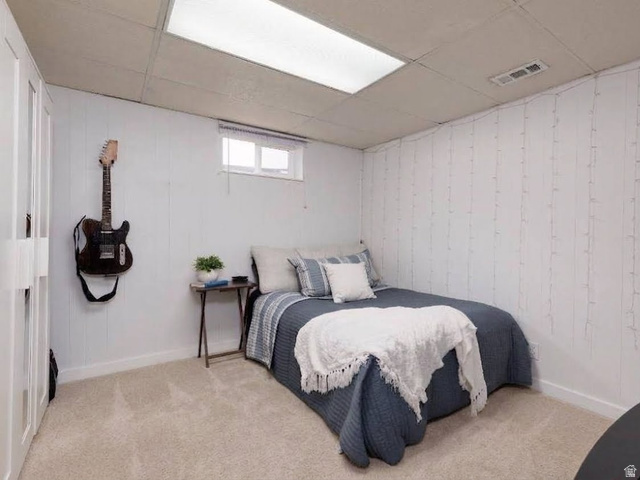8252 Wood Street Midvale, UT 84047 - Photo 17 of 40 Carpeted room featuring white paneling, a drop ceiling, and a single window