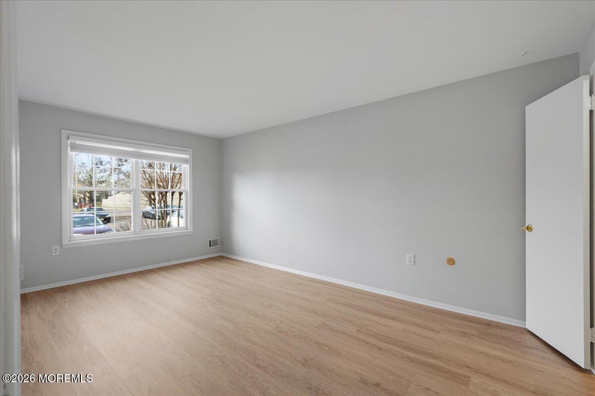 405 Wellington Place Matawan, NJ 07747 - Photo 19 of 29 a view of an empty room with wooden floor and a window
