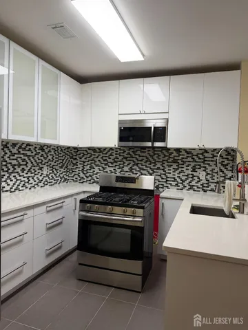 a kitchen with a stove and white cabinets