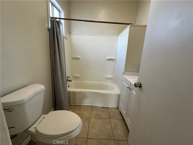 a white toilet sitting next to a bath tub