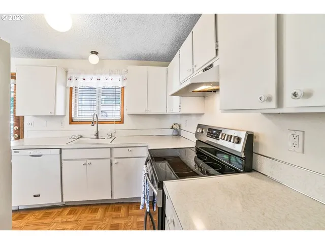 a kitchen with stainless steel appliances granite countertop a stove a sink and a white cabinets