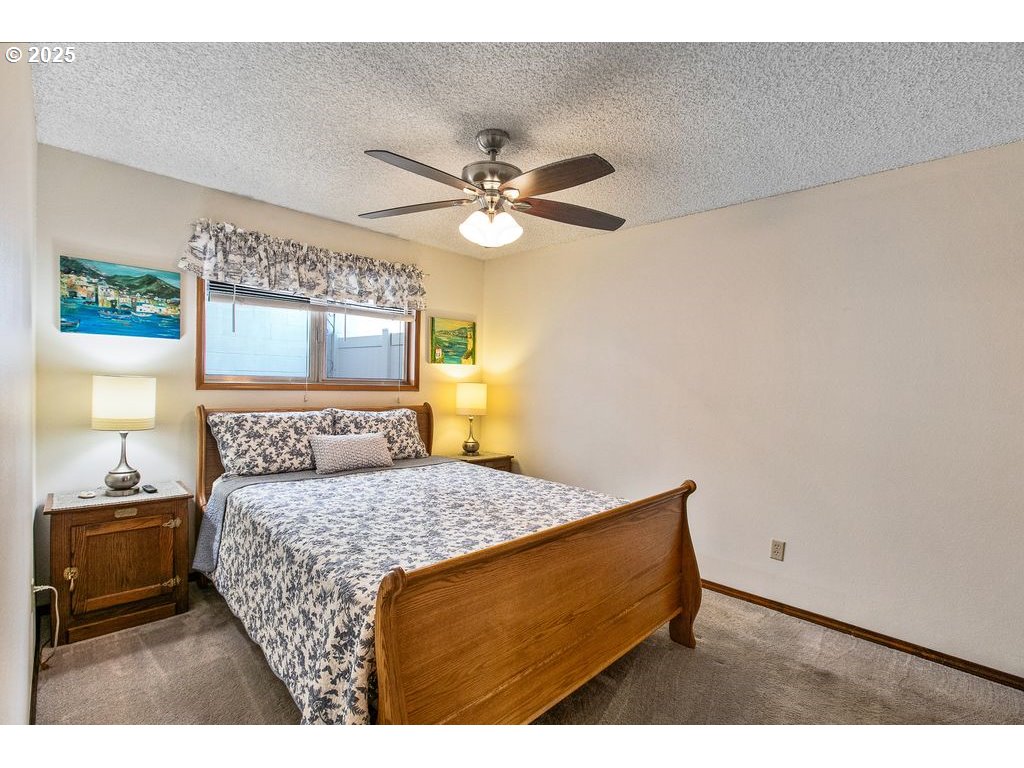 569 Northeast Fleming Avenue Gresham, OR 97030 - Photo 10 of 32 a bedroom with a bed and a chandelier